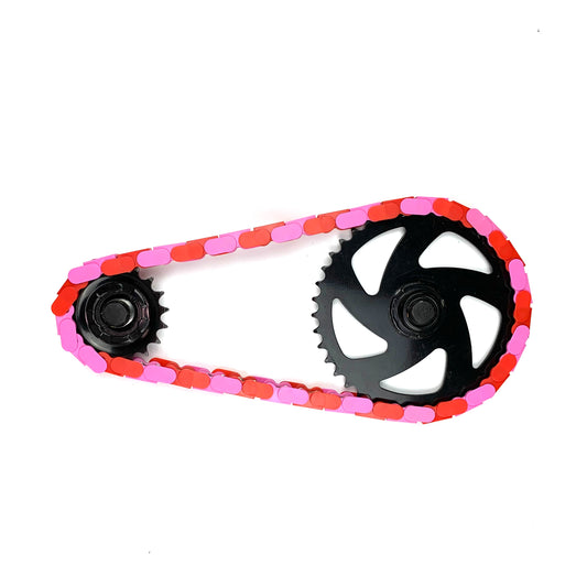 Single Speed Bike Chain in red and pink two tone design, showcasing vibrant colors on a bike gear.