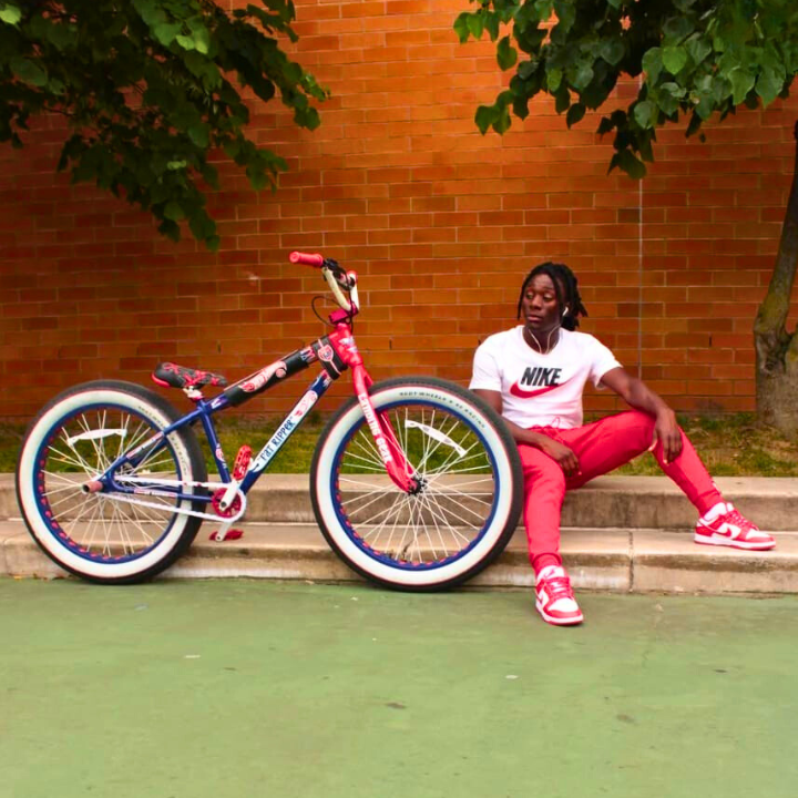 BMX Bikes Best Brands featured with a rider casually posing next to a colorful BMX bike in a park setting.