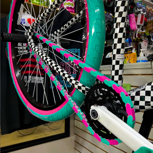 Bike Gifts for Girls – Teal & Pink Two Tone Insane Chains on a colorful bike in a shop.