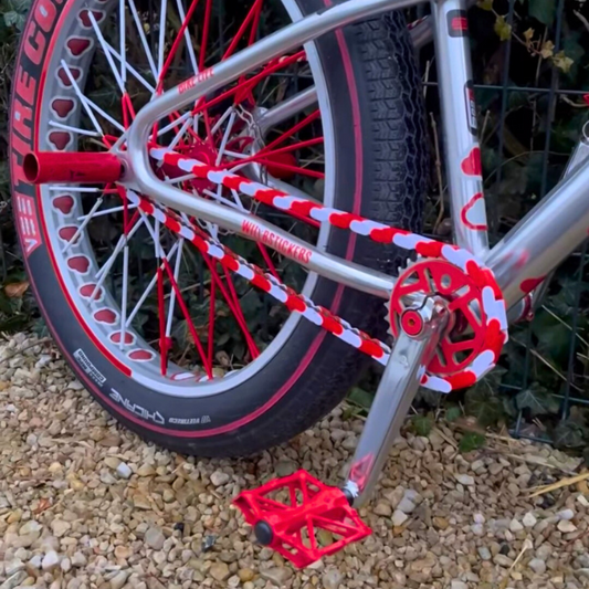 Detail of BMX Bikes Red featuring white and red two-tone Insane Chains and stylish pedals.