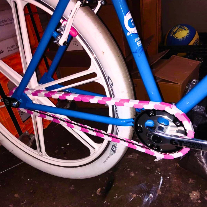 BMX Bikes Pink featuring a two-tone white and pink chain with a blue frame and stylish tires.
