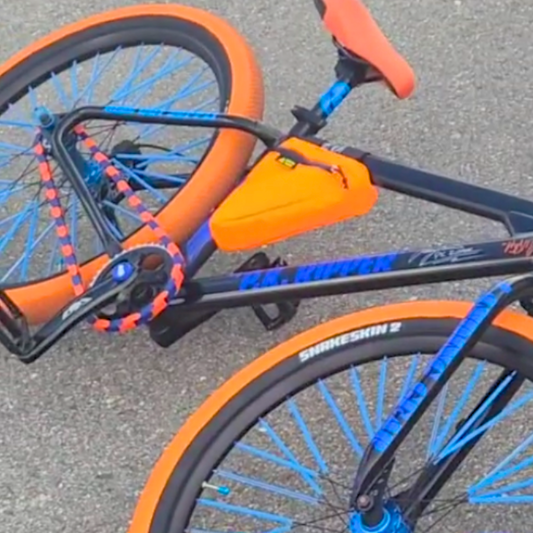 Bike Chain Cover in vibrant purple and orange colors on a stylish bike showcasing a bold, eye-catching design.