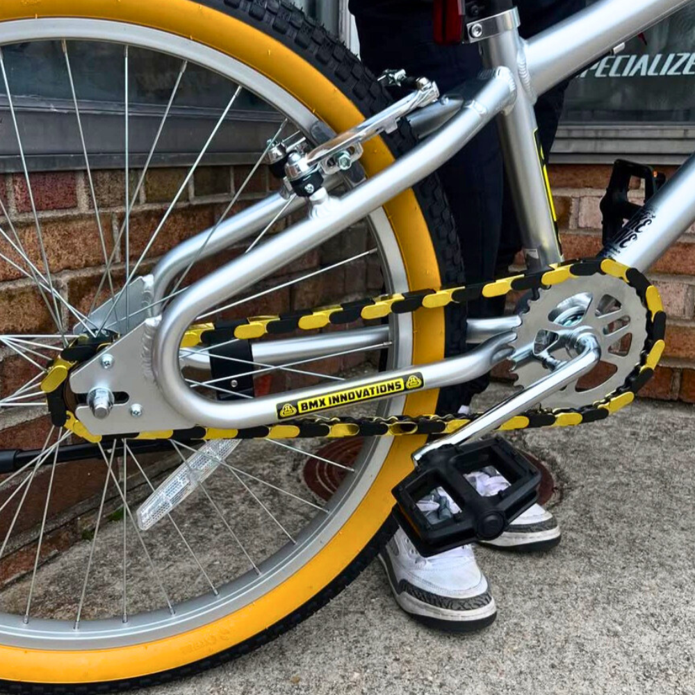 Insane Chains gold and black snap-on bike chain caps on silver SE Basher BMX, custom build from The Bike Cave.