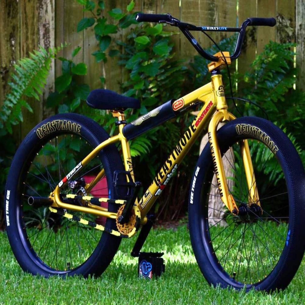 single speed bike chain featured on a bright yellow bike with unique wheels in a lush green setting.