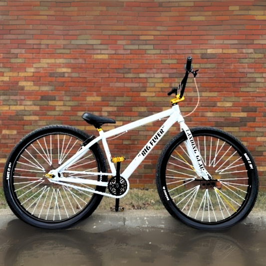 BMX Bikes Best Brands - White bicycle with black tires and yellow accents against a brick background.