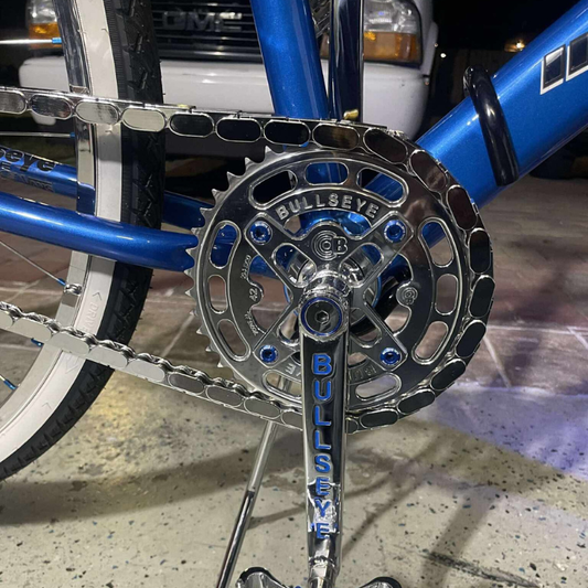 Close-up of a insane chains snapped on bicycle chain and sprocket with 'Bullseye' branding, blurred background