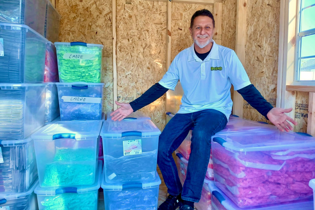 Insane Chains Founder CEO sitting on a stack of Insane Chains Snap on caps storage bins at the Head Quaters