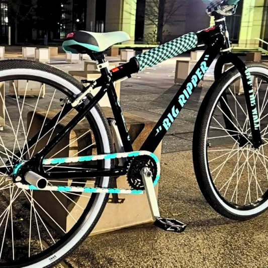 SE Bike Chain showcased on a stylish black bike with teal accents and a checkered grip, promoting vibrant bike aesthetics.