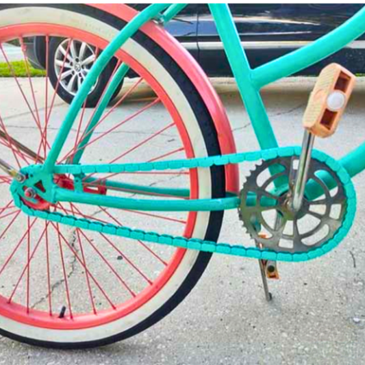 Big Wheelie bike chain featuring teal snap-on caps and colorful wheels on a bicycle.