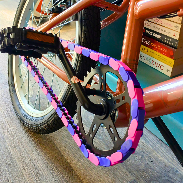 Childrens Bike 14 Inch with purple and pink two tone snap-on chain caps showcasing vibrant colors.