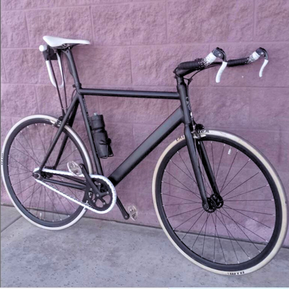 BMX Bikes Best Brands - black bicycle with white accents against purple wall.